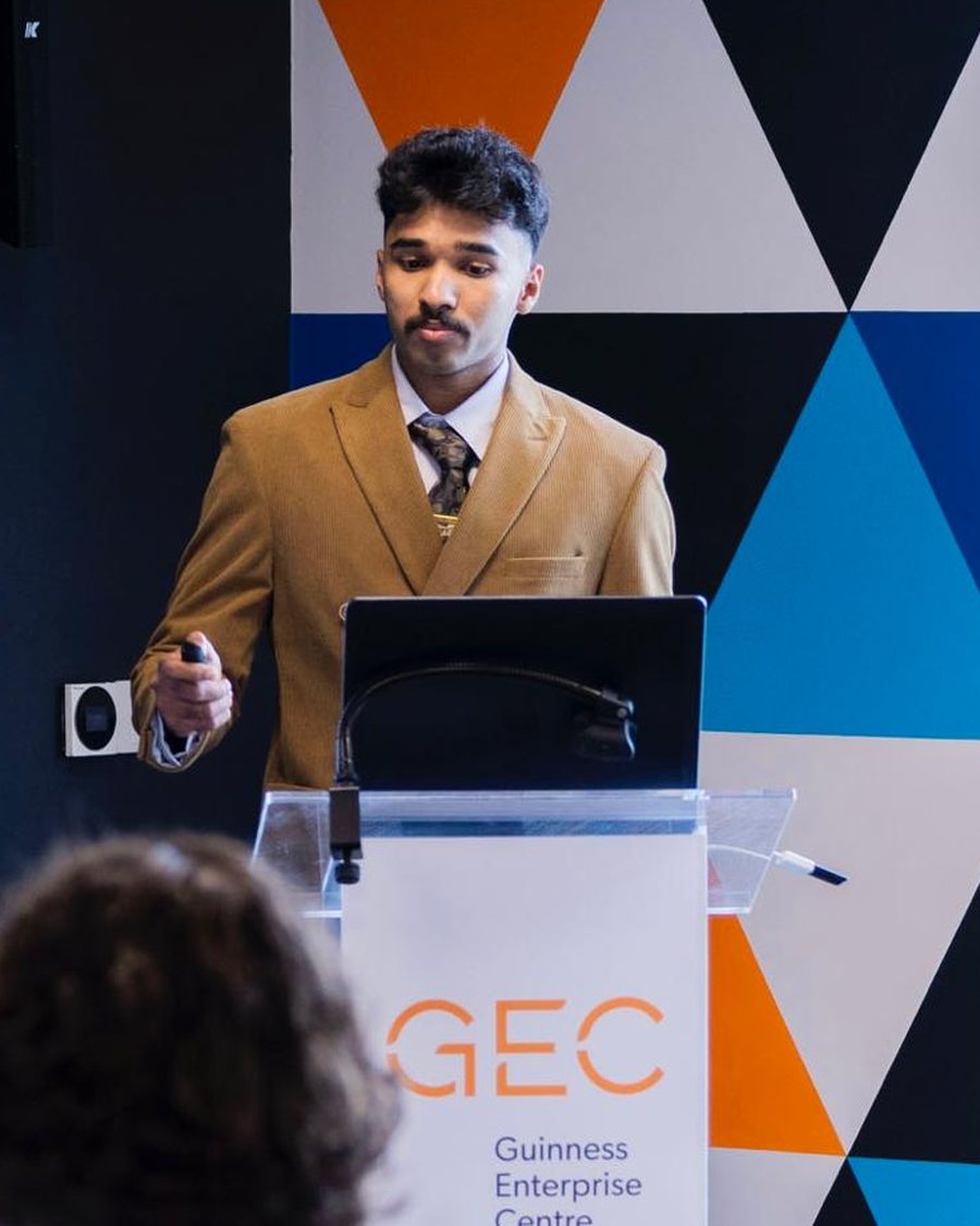 Goutham presenting at a podium at the Guinness Enterprise Centre.